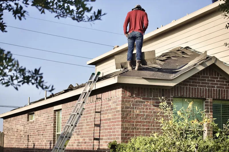 Professional roofer working on a residential roof in West Seventh